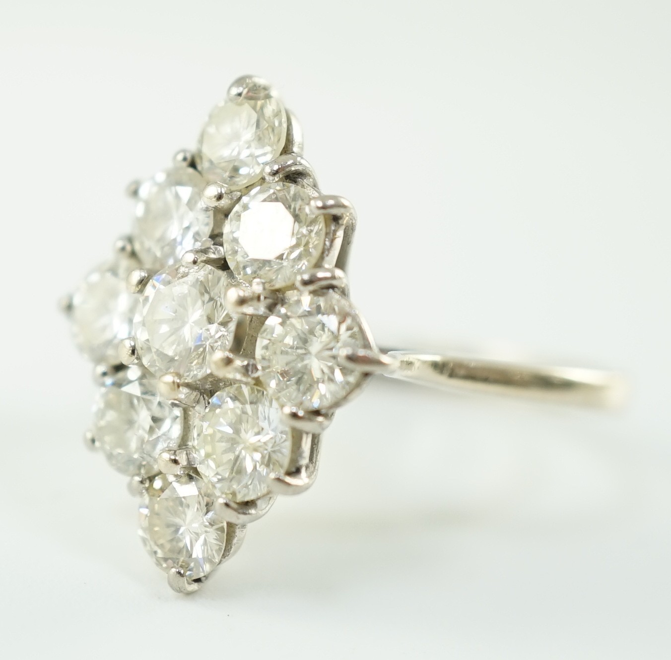 An 18ct white gold and nine stone diamond cluster set marquise shaped diamond ring